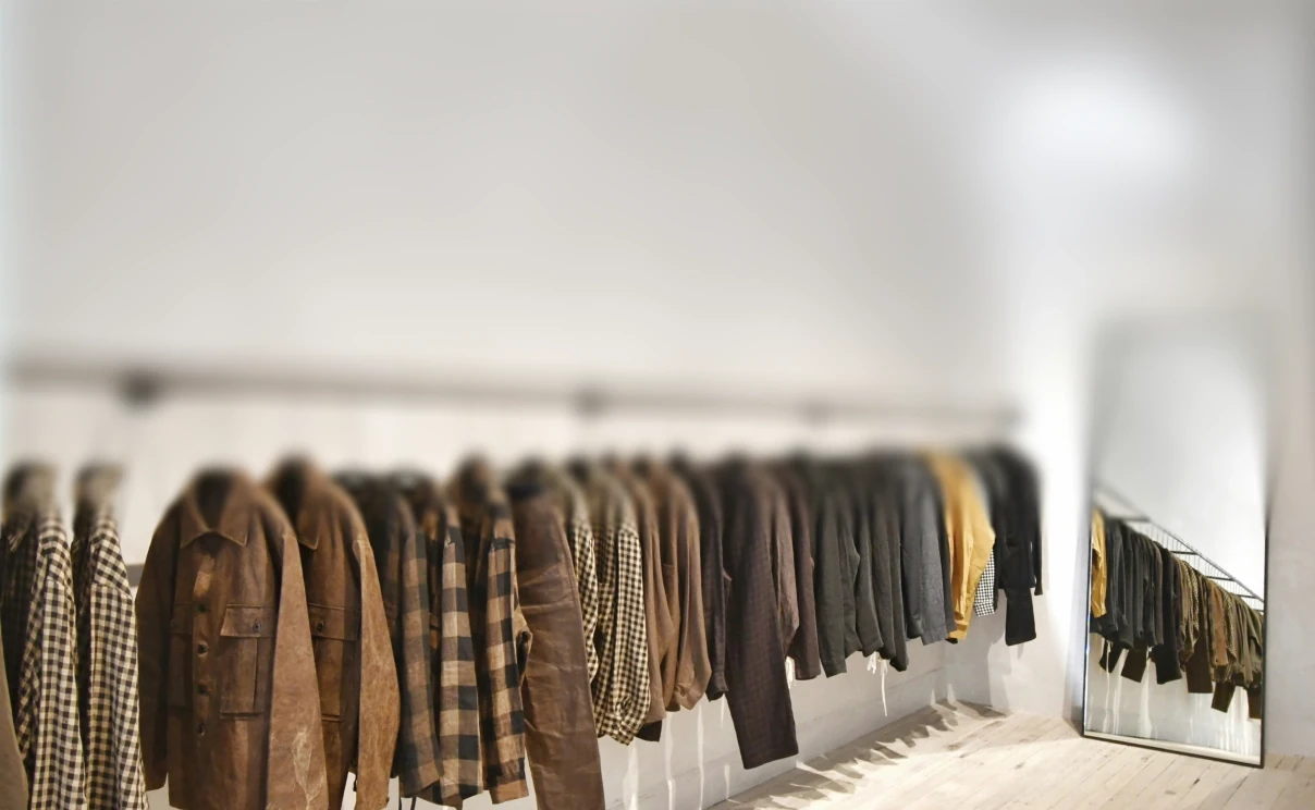 A rail of jackets in a boutique, the kind of catalogue the agent answers from.